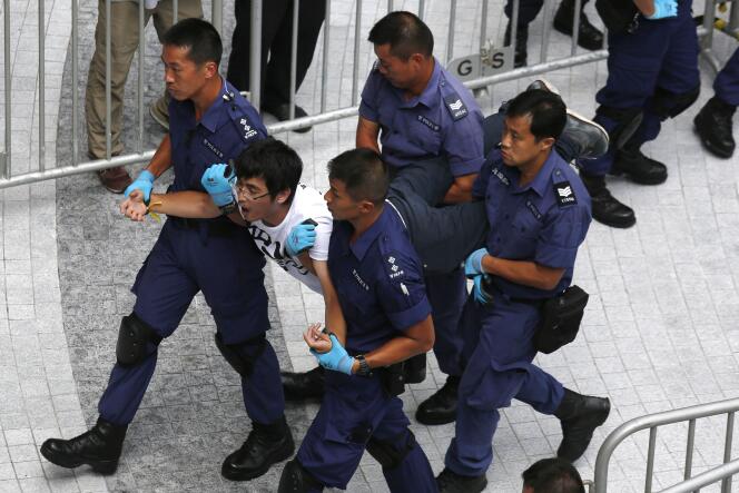 Alex Chow, secrétaire général de la Fédération des étudiants de Hongkong, emporté par la police le 27 septembre 2014.