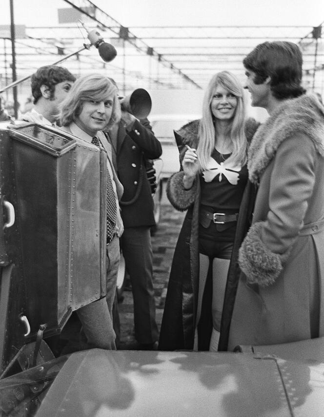 L'actrice française Brigitte Bardot discute avec les pilotes automobiles François Cevert et Johnny Servoz-Gavin (à gauche), le 12 février 1971, lors du 2e Salon de la voiture de course et de la moto qui se tient au Grand Palais à Paris.