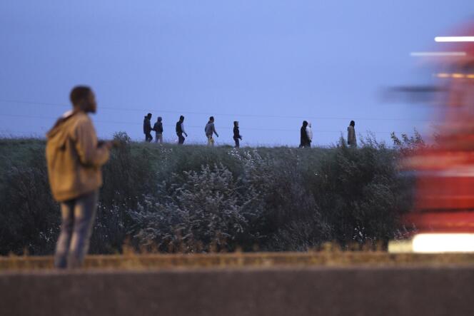 Des migrants qui vont tenter de grimper dans un camion à destination de l'Angleterre, jeudi 23 octobre, à Calais.