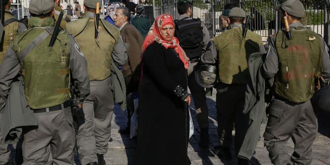 Une femme devant un patrouille israélienne lors des funérailles d'un jeune Palestinien, le 26 octobre.
