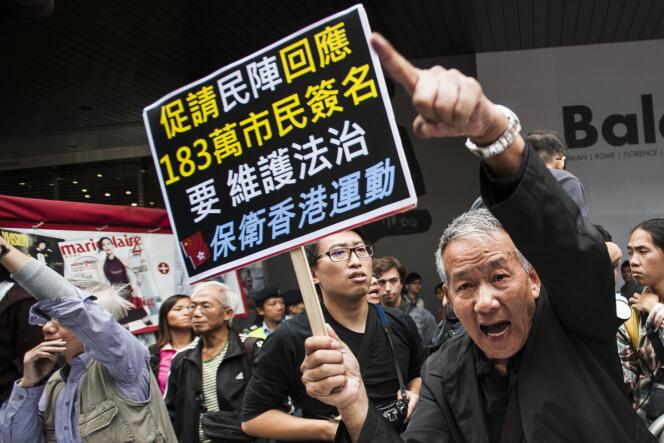 Un manifestant pro-Pékin interpellent les démocrates dimanche 9 novembre dans les rues de Hongkong.
