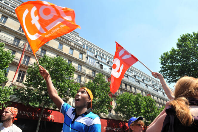 Des salariés des grands magasins Galeries Lafayette, Printemps et Bon Marché manifestent le 30 juin 2010 à Paris devant les Galeries Lafayette pour protester contre le travail dominical et les bas salaires.
