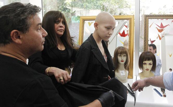 Un coiffeur prépare une perruque faite de cheveux naturels pour une adolescente qui a perdu les siens après une chimiothérapie.