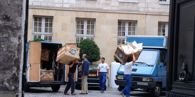 Des déménageurs transportent des caisses dans la cour de l'hôtel particulier du député des Bouches-du-Rhône Bernard Tapie le 28 juillet 1994, à Paris, où une saisie de meubles et d'objets d'art a été opérée à la demande du Crédit Lyonnais.