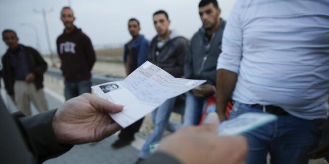 Des travailleurs palestiniens lors d'un contrôle d'identité à la sortie de la ville israélienne d'Ashkelon, le 11 novembre.