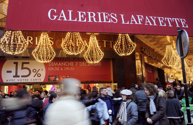 Des personnes regardent les vitrines d'un grand magasin ouvert ce dimanche à l'approche de Noël, le 07 décembre 2008 à Paris.