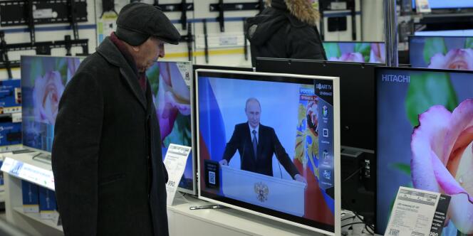 Un client d’une grande surface, à Moscou, regarde l’allocution annuelle du président Vladimir Poutine sur l’état de la nation, en décembre  2014.
