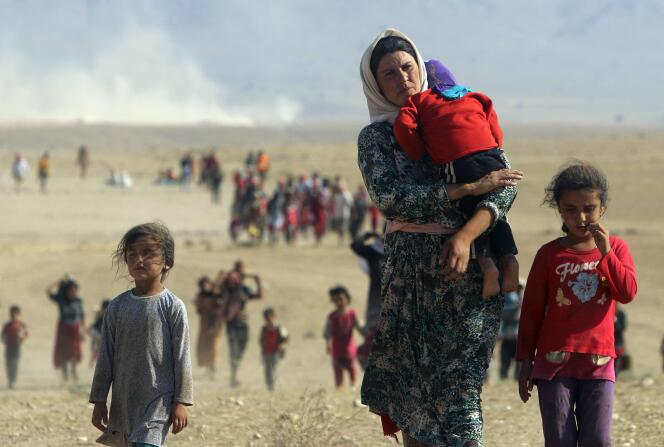 Une mère yézidie fuit la région de Sinjar vers la frontière syrienne, à travers un corridor ouvert par le Parti des travailleurs du kurdistan (PKK), le 11 août 2014.