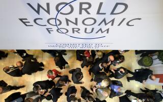 (FILES) A file picture taken on January 25, 2012 shows participants at the World Economic Forum (WEF) annual meeting standing under a sign reading 'World Economic Forum' at the Congress Center in Davos. World leaders including France's Francois Hollande, Germany's Angela Merkel and China's Li Keqiang will gather at the annual Davos forum running from January 21 until January 24, 2015, seeking to chart a path away from fundamentalism towards solidarity.AFP PHOTO / FABRICE COFFRINI