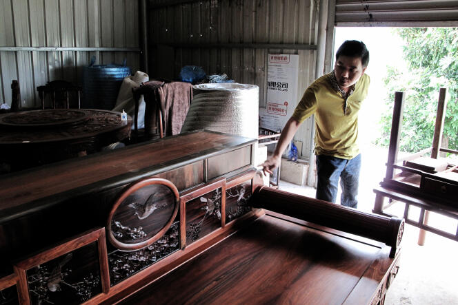 Dans son magasin, Li Sheng Peng, directeur de Yimu Xian Ju, montre un lit fabriqué en bois de rose de Madagascar.