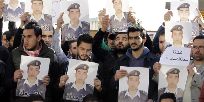 Des Jordaniens brandissent des portraits du pilote Maaz Al-Kassasbeh, 26 ans, brûlé vif par l'Etat islamique dont il était otage depuis le 24 décembre. 