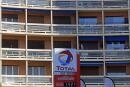 A logo is seen over prices at French oil and gas company Total gas station in Marseille, February 11, 2015. The French oil and gas company Total SA will present its 2014 annual results on Thursday. REUTERS/Jean-Paul Pelissier (FRANCE - Tags: BUSINESS ENERGY LOGO)