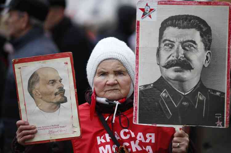 Une militante communiste brandissant les portraits de Lénine et Staline, dans le défilé de la "Journée des défenseurs de la patrie", à Moscou, le 23 février.