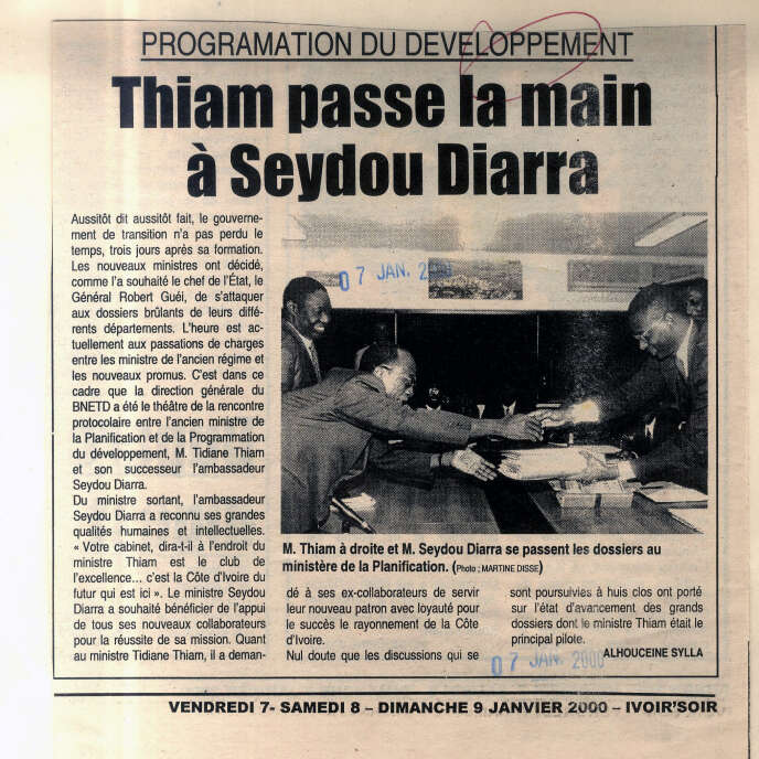 Le 6   janvier 2000, juste après le coup d’Etat militaire, Tidjane Thiam, à droite, est contraint de remettre devant un photographe les dossiers du ministère de la Planification de Côte d’Ivoire qu’il dirigeait.