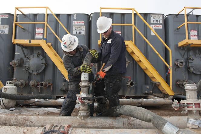 Deux techniciens préparent une extraction par fracturation hydraulique, dans le Dakota du Nord, en novembre 2014.