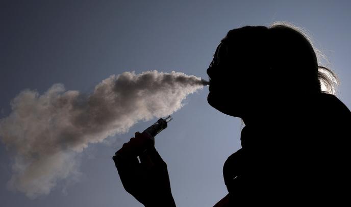 Une femme vapote sa cigarette électronique.