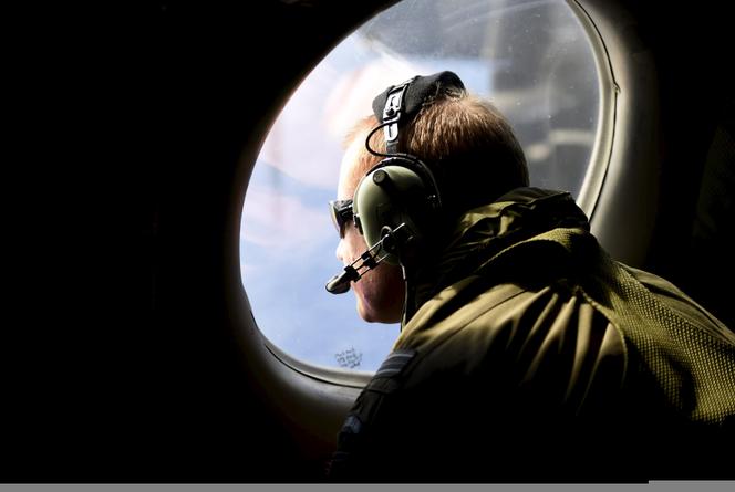 Un membre d’équipage d’un avion de patrouille maritime survolant l’océan, à la recherche du MH370, le 11 avril 2014.