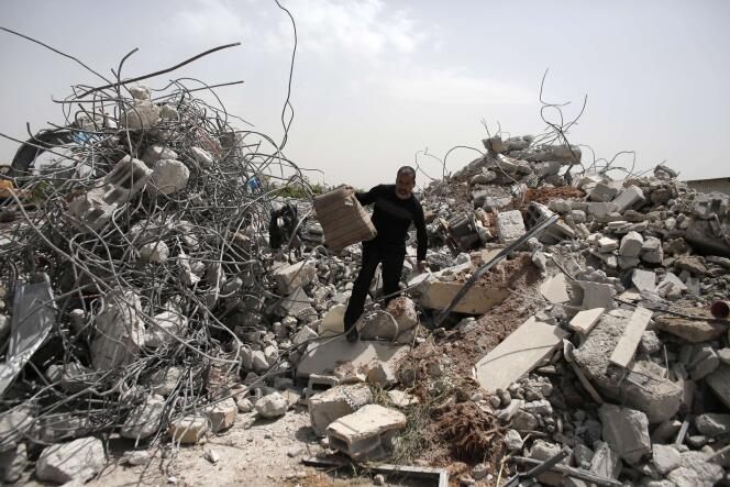 Un homme marche sur les ruines d'une maison précédemment occupée par des Arabes israéliens et détruite par les autorités israéliennes, à Lod, près de Tel-Aviv.