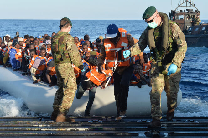 Des soldats de la marine anglaise aident des migrants à descendre d'un canot de sauvetage après avoir été sauvés d'un naufrage au large des cotes de Libye, le 13 Mai 2015.