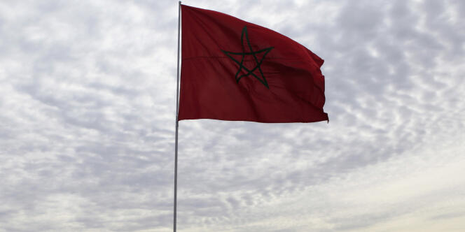 Un policier se tient près du drapeau du Maroc, à Agadir, le 10 décembre 2013.