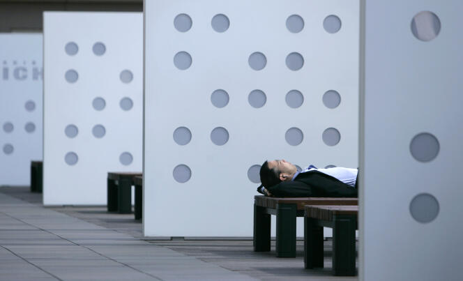 Un businessman fait la sieste sur un banc à Tokyo le 8 juin 2007.