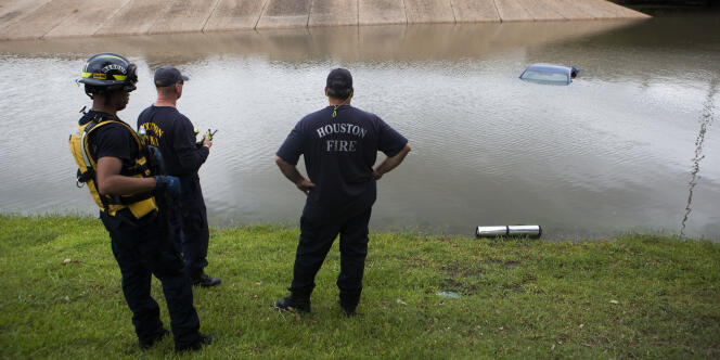 Les pompiers de Houston regardent une voiture noyée, mardi 26 mai, suite aux fortes précipitations de la veille.