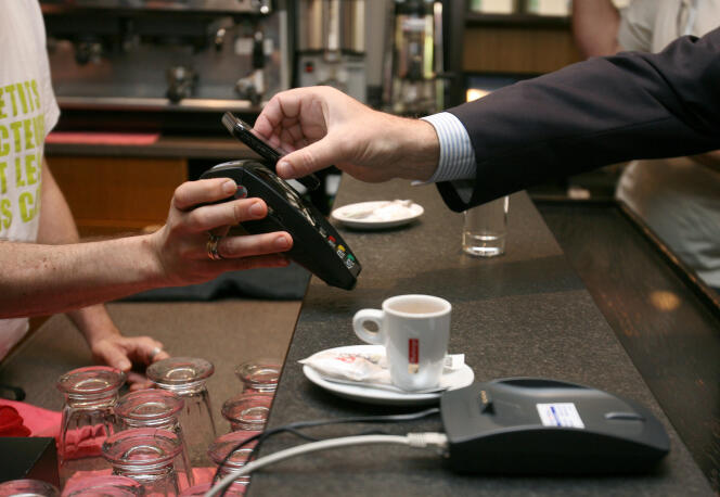 Un téléphone portable est utilisé pour effectuer un paiement sans contact.  En mai 2010, à Nice, lors de la présentation d’un plan pour développer « l’économie du sans contact ». 