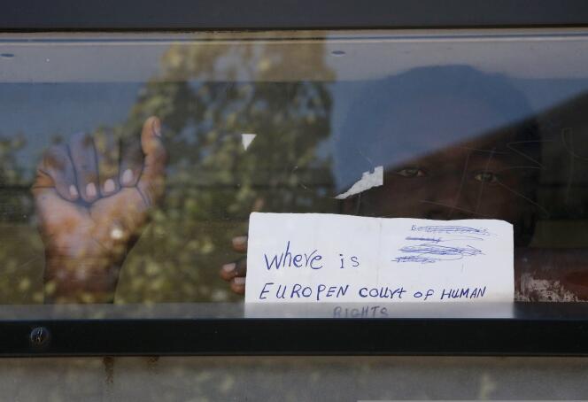 Un migrant affiche à la vitre d'un bus un mot qu'il a écrit où il est inscrit : « Où est la Cour européenne des droits de l'homme ? », lundi 8 juin.