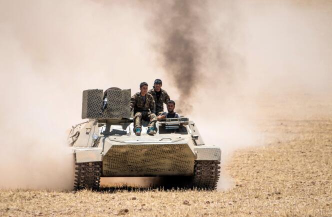 Des combattants kurdes des YPG aux commandes d'un char, à l'entrée est de Tal Abyad.