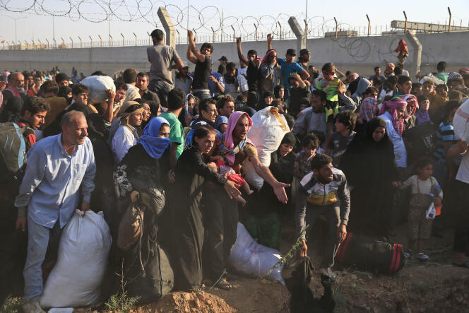 Des réfugiés syriens pénètrent en Turquie, après avoir franchi des réseaux de fil de fer barbelé, non loin d'Akçakale, le 14 juin.