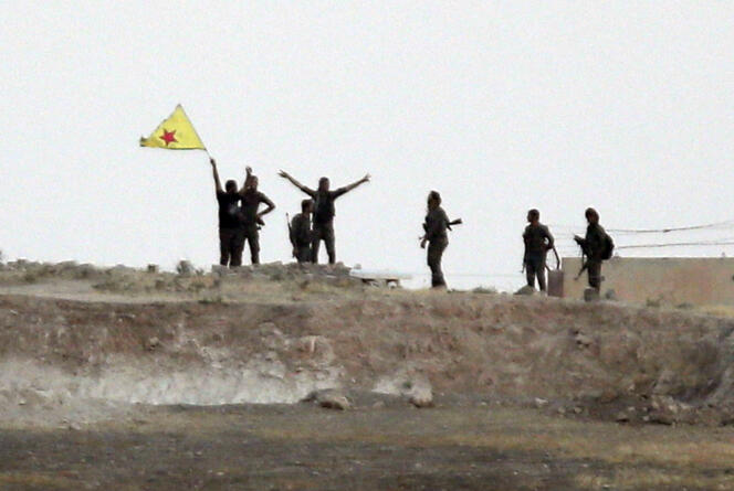 Sur cette photo prise du côté turc de la frontière, à Akçakale, on distingue des combattants du  YPG, qui ont pris, mardi 16 juin, le contrôle de Tal Abyad, en Syrie, jusque-là aux mains de l'Etat islamique.
