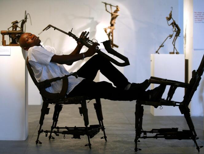 Le sculpteur Gonçalo Mabunda au milieu de quelques-unes de ses oeuvres réalisées à partir d'armes recyclées.