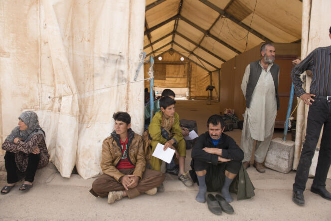 Au poste-frontière d'Islam-Qala, en Afghanistan, des immigrés clandestins afghans, expulsés d'Iran, attendent d'être pris en charge par l'Organisation internationale pour les migrations (OIM).