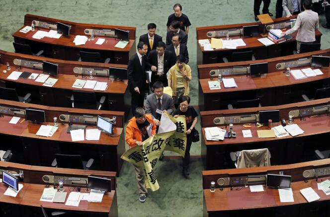 Des parlementaires pro-démocratie, jeudi 18 juin, au Conseil législatif de Hongkong. Sur la banderole : « Rouvrez la réforme politique pour défendre Hongkong, n’abandonnez jamais le combat pour un vrai suffrage universel ».