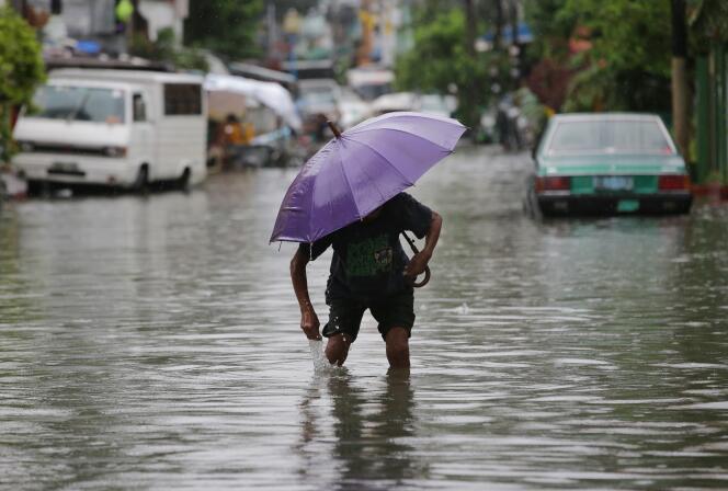 Un homme dans les rues de Quezon , au nord de Manille, aux Philippines, le jeudi 9 juillet 2015. Les fortes pluies du typhon Chan-Hom ont intensifié la mousson saisonnière.