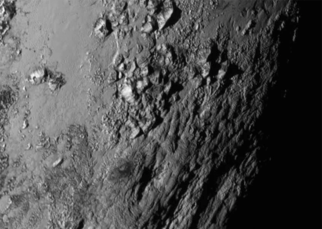 Gros plan pris par la sonde New Horizons d'une région de Pluton proche de l'équateur révélant des montagnes de glace hautes de 3 500 mètres.