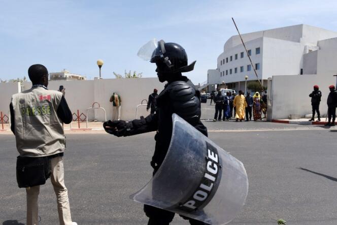 Un policier tente d'empêcher un journaliste de prendre des photos, à Dakar en mars 2015.