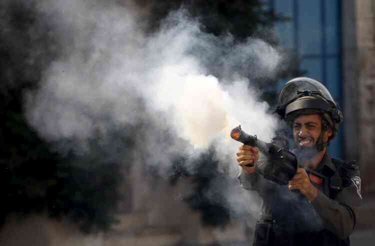 Un policier israélien tire du gaz lacrymogène contre les manifestants palestiniens à Hebron.