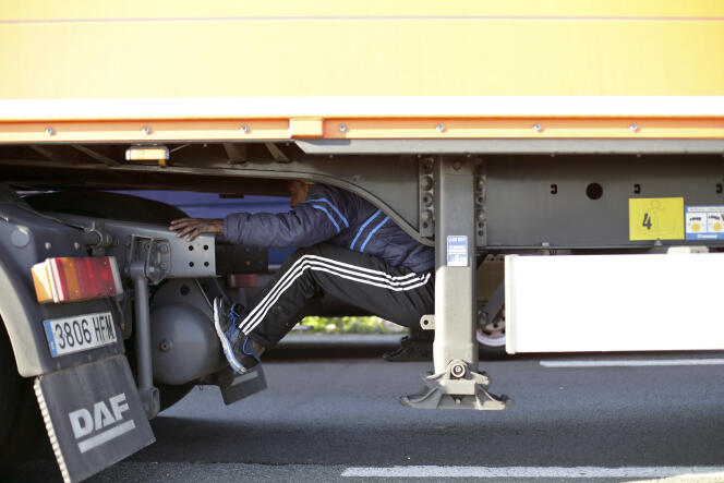 Caché sous la remorque d'un camion, un migrant tente de passer la frontière avec le Royaume-Uni, le 24 juin, à Calais.