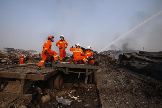 Des pompiers chinois à Tianjin, sur le site des explosions qui ont secoué la ville le 12 août au soir.