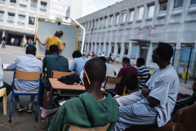 Un cours de français dispensé, le 6 août, aux migrants qui occupent l'ancien lycée Jean-Quarré à Paris.