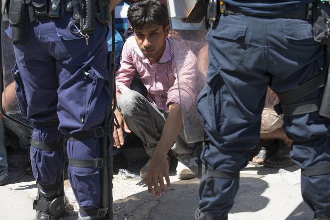 Des policiers encadrent des migrants qui attendent leur enregistrement auprès de l'administration, à Kos, le 19 août.
