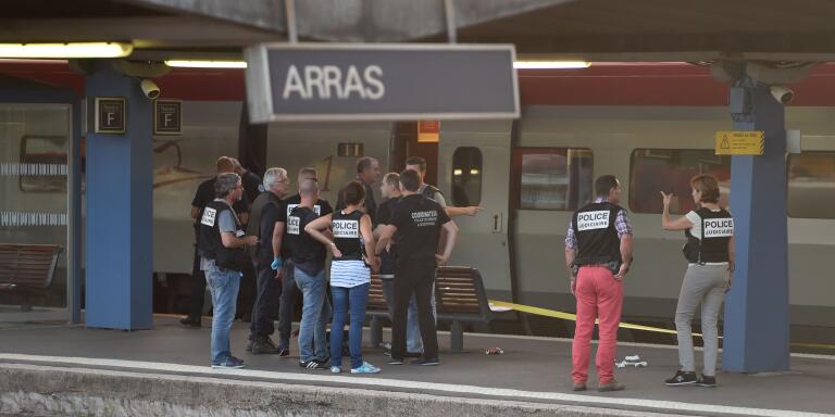 Crime and forensic investigators stand on a platform next to a Thalys train of French national railway operator SNCF at the main train station in Arras, northern France, on August 21, 2015. A gunman opened fire on a train travelling from Amsterdam to Paris, injuring three people before being overpowered by passengers, French state rail company SNCF and rescue services said. Two of the victims were seriously injured and at least one suffered gunshot wounds, an SNCF spokesman said, adding that the assailant was armed with guns and knives. The motives behind the attack were not immediately known. AFP PHOTO / PHILIPPE HUGUEN
