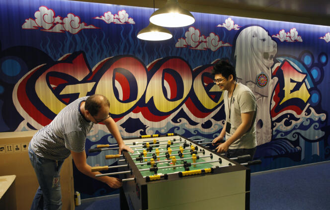 Des employés jouent au baby-foot dans les locaux de Google à Singapour en juillet 2013.