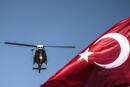 Turkish army helicopter flies behind a Turkish flag during a military parade marking the 93rd anniversary of Victory Day in Istanbul on August 30, 2015. Turkey commemorates the anniversary of the day in 1922 that marked the end of Turkey's independence war with a victory over Greek troops in Anatolia. AFP PHOTO / OZAN KOSE