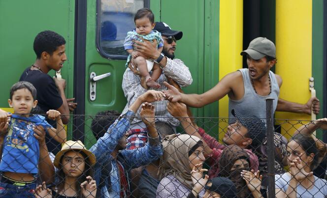 Des réfugiés devant le train dans lequel ils ont passé la nuit à la gare de Bicske, en Hongrie, le vendredi 4 septembre. Ils refusent d'aller dans un camp de transit.