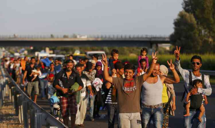 Certains migrants faisaient le V de la victoire en marchant le long de l'autoroute.