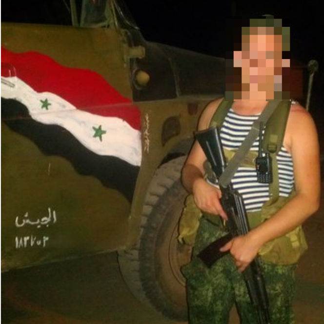 Pavel N., soldat natif de Sébastopol, prenant la pose devant un camion arborant le drapeau syrien.