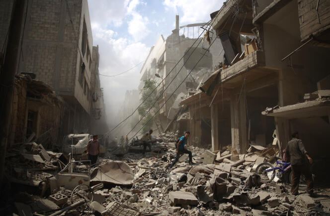 Des habitants dans les décombres de Douma ville syrienne tenue par les rebelles à l'est de Damas, le 30 août 2015.