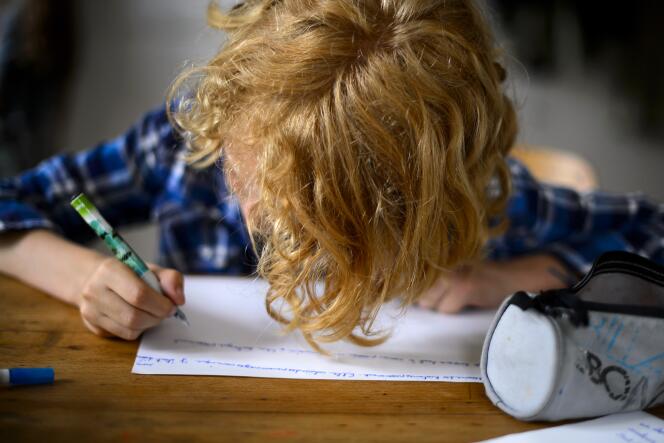 Un enfant fait ses devoirs scolaires à Moudon, en Suisse, en 2013.